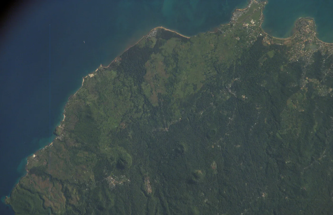 Green volcanic ridges and the coastline of São Tomé island seen from orbit