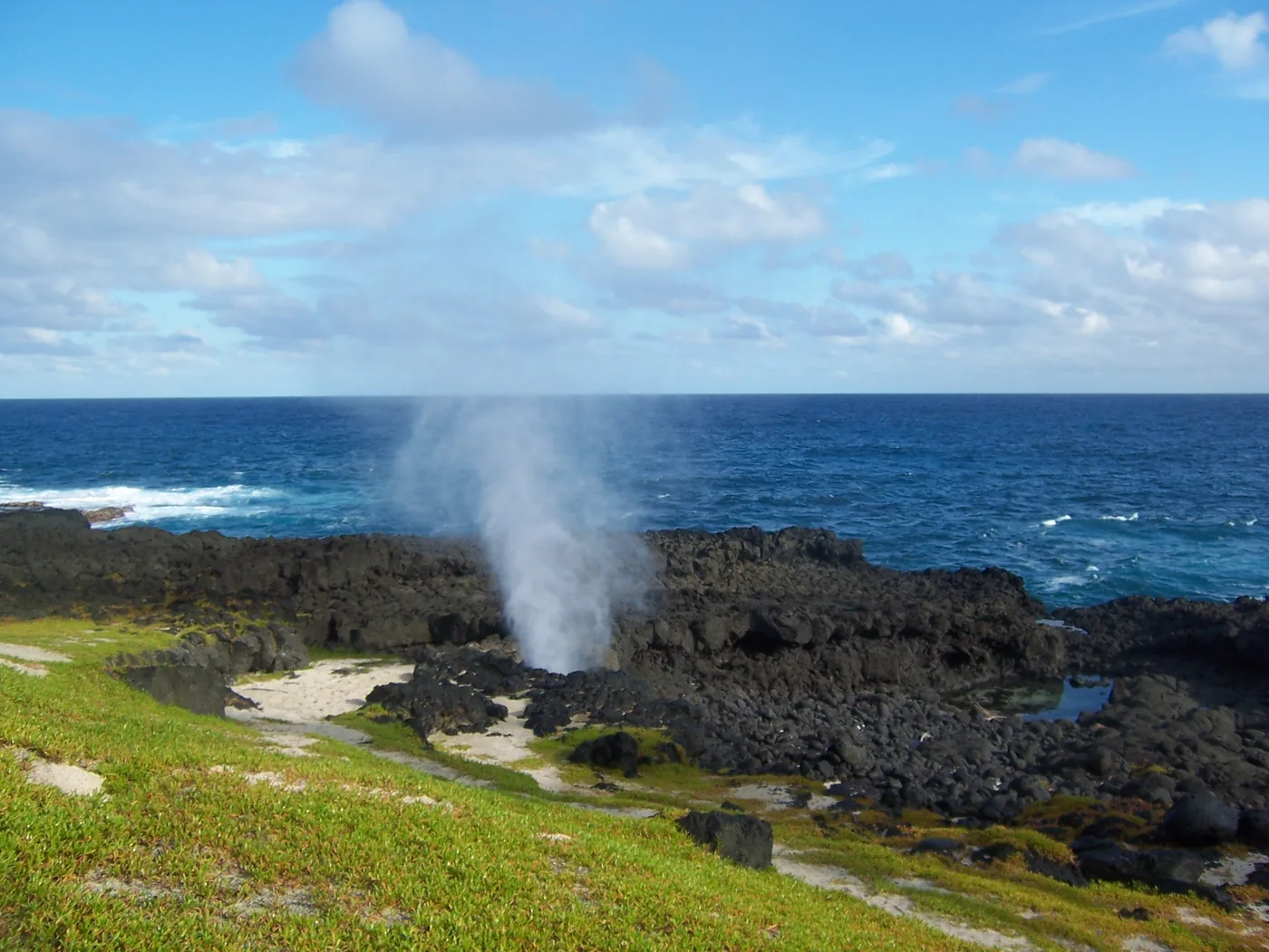 Sea spray shooting up from the volcanic rocks of the blowhole on Ilhéu das Rolas, south of São Tomé